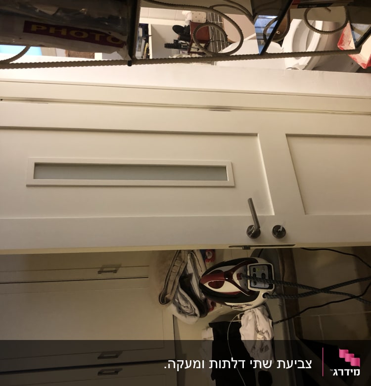 דלת לבנה עם ידית מתכת ומסגרת זכוכית